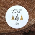 Naklejki z logo z grafiką choinek w wersji beżowo-czarnej okrągłe