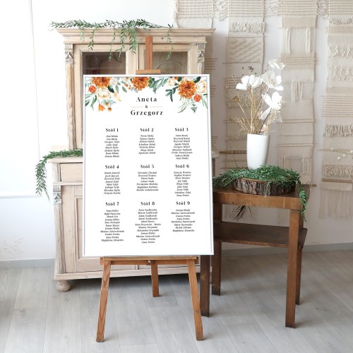 Duży plan stołów weselnych z pomarańczowymi kwiatami