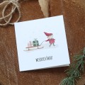 Świąteczna kartka firmowa z akwarelowym skrzatem ciągnącym sanki z prezentami