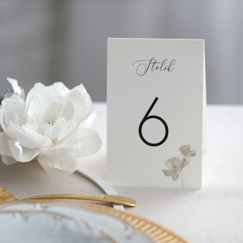 Numerek na stół stojący z białym kwiatem
