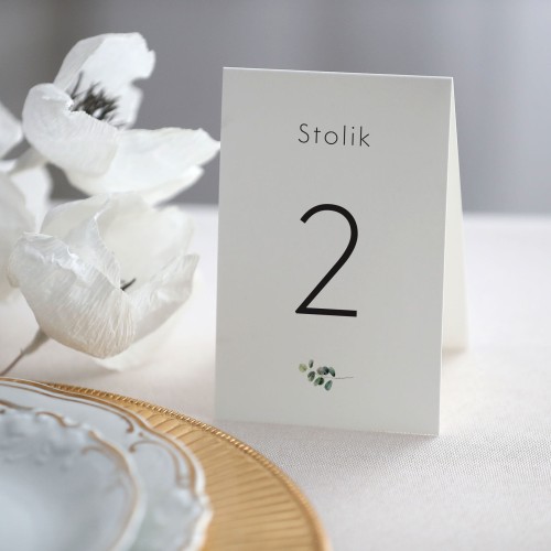 Numerek na stół stojący z eukaliptusem